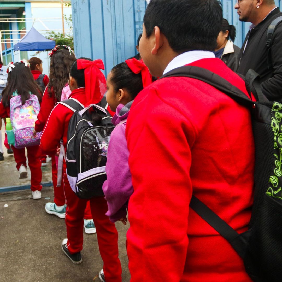 Niños con uniforme ingresan en fila a la escuela
